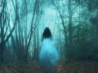 Een geest van een doorzichtig meisje in een witte jurk loopt een mistig, spookachtig bos in op bevrijdingsdag