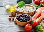 op een houten tafel ligt gezonde voeding waarmee je kunt afvallen: Zalm, note, groenten en blauwe bessen.