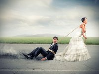 Een bruid in trouwjurk sleept haar kersverse echtgenoot over het asfalt. Zij moeten leren communiceren in hun relatie.
