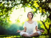 Een vrouw is aan het mediteren en voelt innerlijke rust.