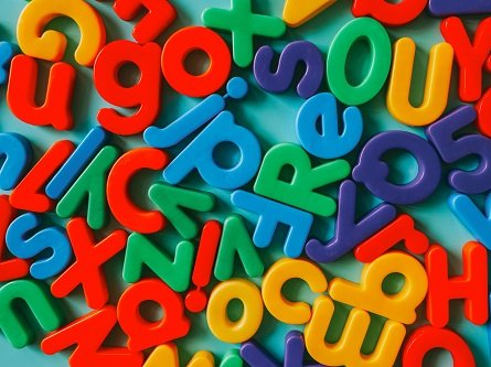 Een heleboel gekleurde letters waar een stotteraar moeite mee zou hebben liggen kriskras door elkaar