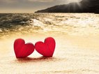 Twee tweelingzielen hebben elkaar gevonden en voelen innerlijke rust: twee harten staan tegen elkaar aan op het strand.