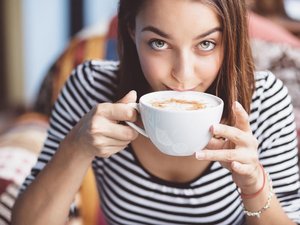 Een vrouw heeft last van hooggevoeligheid en hoogsensitiviteit, en ze geniet van een kop koffie