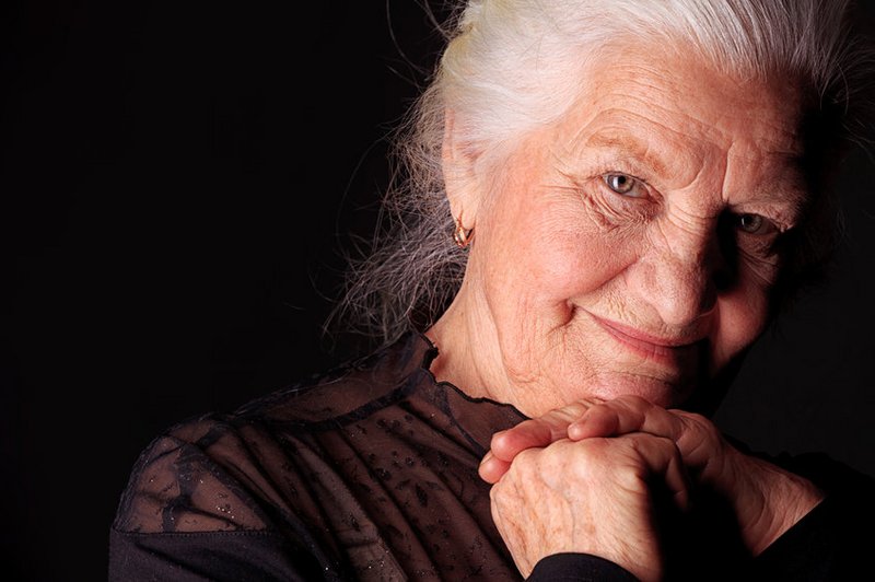 Oudere dame kijkt tevreden omdat ze eindelijk verlost is van oude boosheid.