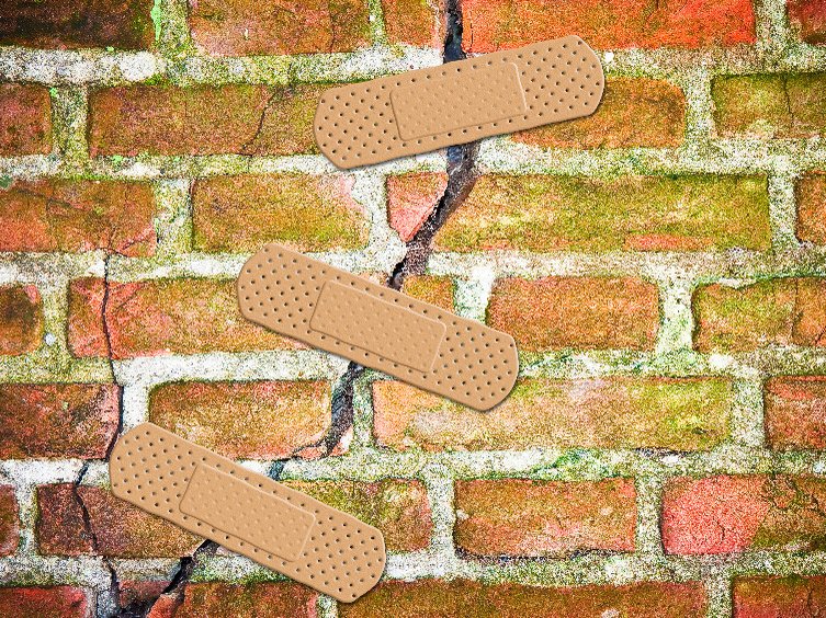 Een muur met een trauma: een bakstenen muur met een grote barst erin. Drie pleisters zijn over de barst geplakt.