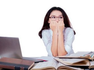 Een vrouw met sollicitatie angst zit heel angstig achter haar laptop.