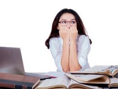 Een vrouw met sollicitatie angst zit heel angstig achter haar laptop.