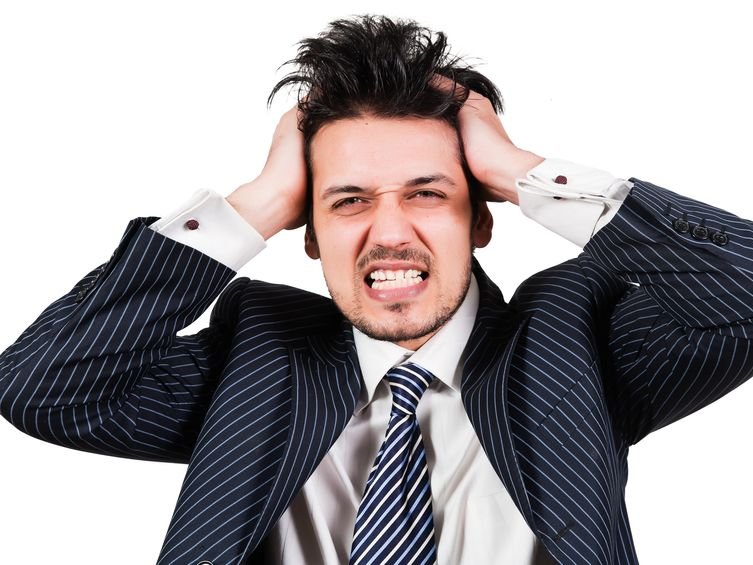 Een man houdt zijn handen tegen zijn hoofd om zichzelf te beschermen tegen negatieve energie van anderen.