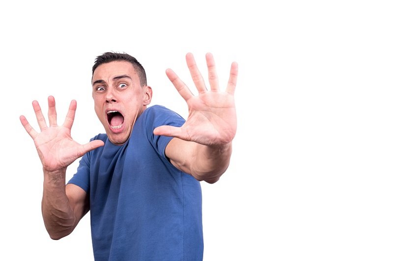 Een man met een fobie houdt zijn handen afwerend voor zich uit gestrekt om het onderwerp van zijn fobie op een afstand te houden