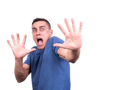En hypervigilante man heeft een fobie en houdt zijn handen afwerend naar de camera