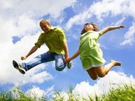 Een man en een meisje springen blij de lucht in.