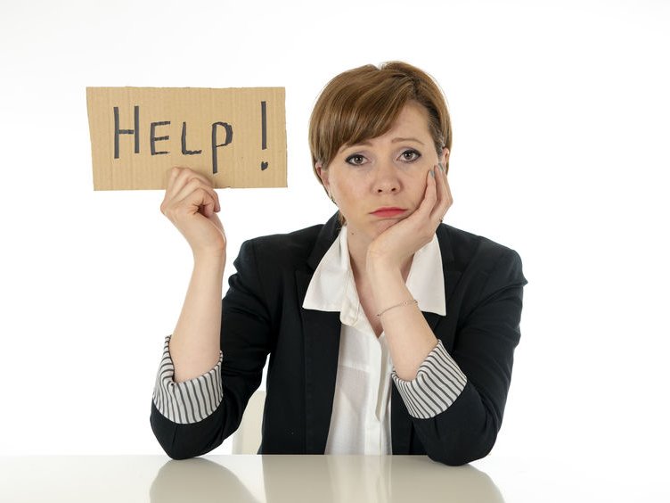 Een vrouw in nette kleren kijkt bezorgd en houdt een bordje omhoog met daarop geschreven "HELP".