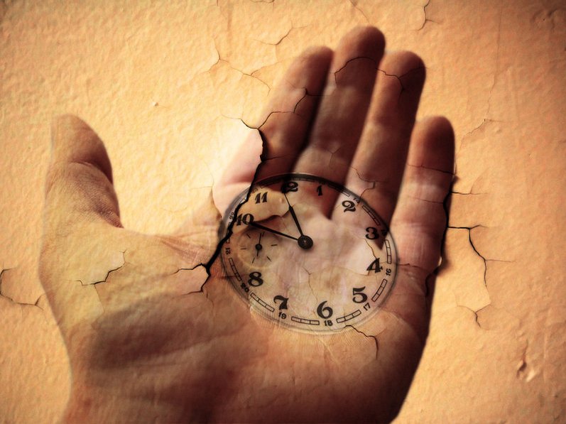 Een hand met een klok, die aangeeft dat het trauma ook al in het verleden speelde.