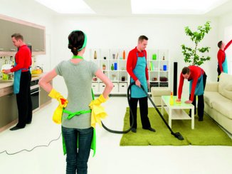 Een vrouw heeft goede communicatie met haar man en staat te kijken hoe hij helpt met het schoonmaken van het huis.