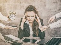 Een hooggevoelige vrouw achter een bureau is burn-out, mensen om haar heen wijzen op de klok, en zetten haar onder druk.