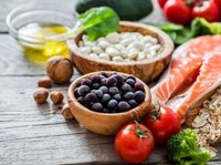 op een houten tafel ligt gezonde voeding: Zalm, noten, groenten en blauwe bessen.