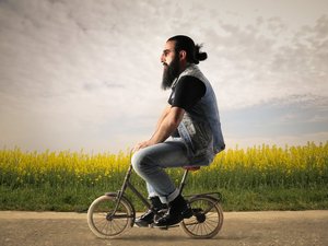 hipster met een baard op een klein fietsje