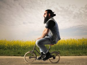 hipster met een baard op een klein fietsje