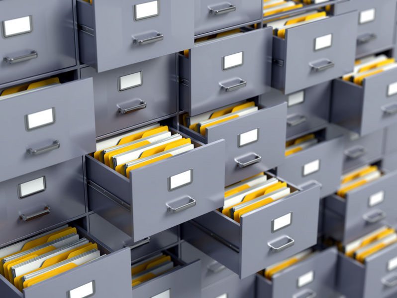 Een archiefkast vol dossiers en mappen. Alle laatjes staan open.