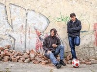 Twee pubers staan verveeld voor een muur met graffiti, hun hooggevoelige moeder weet niet hoe ze er mee om moet gaan.
