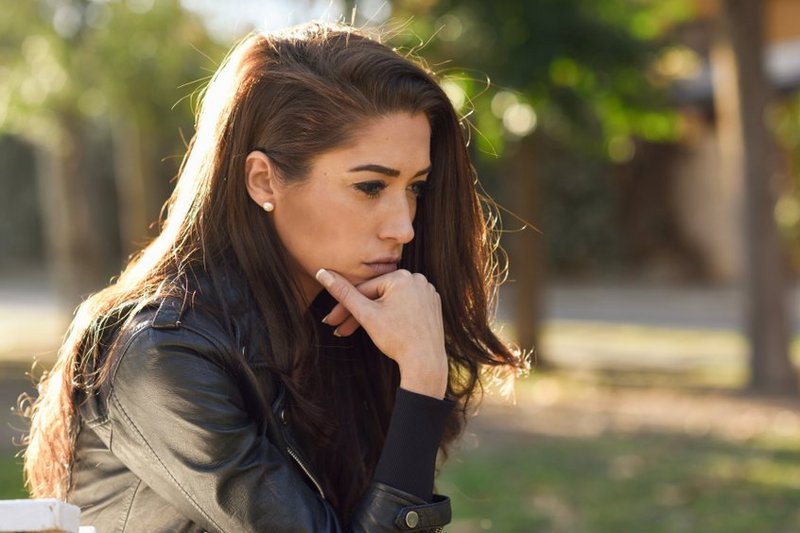 Een vrouw met een trauma staart voor zich uit. Ze wil haar trauma zelf verwerken zonder hulp.