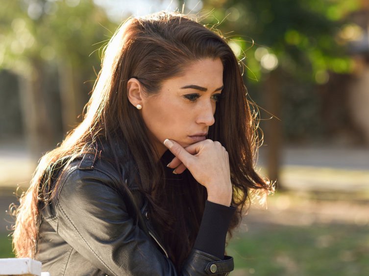Een vrouw met een trauma staart voor zich uit. Ze wil haar trauma zelf verwerken zonder hulp.