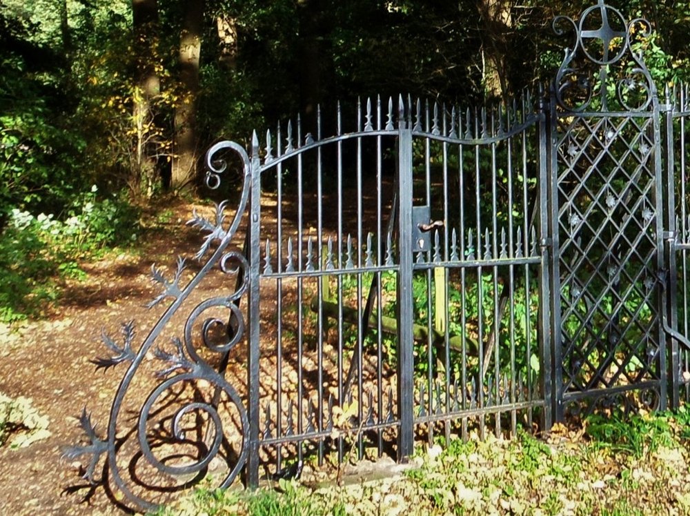 Een symbolisch beeld van het onderbewuste: Een een pad dat een donker bos in loopt wordt afgesloten door een zwart gietijzeren hek. Maar een smal pad loopt er met een bochtje omheen.