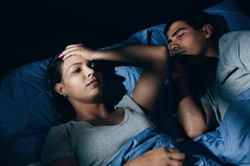 Een vrouw met een grote aura kan niet slapen omdat haar man in haar aura ligt