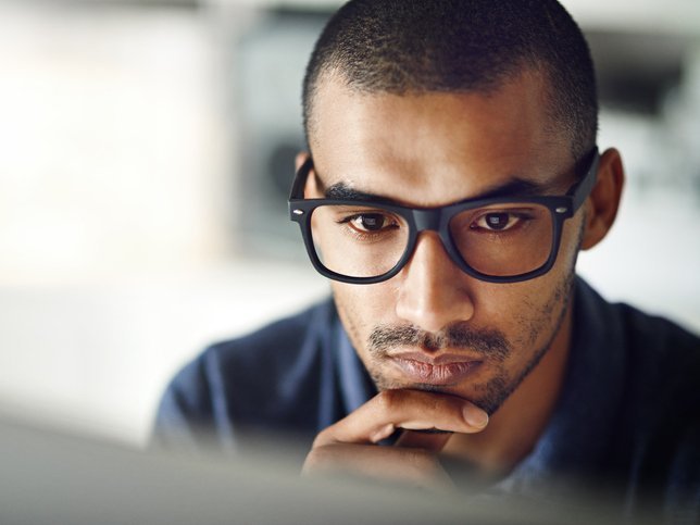 Een man kijkt met een goede concentratie naar zijn computerscherm