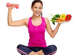 Een vrouw in sportkleding zit in kleermakerszit. In de ene hand een gewicht, in de andere een bord gezonde voeding.