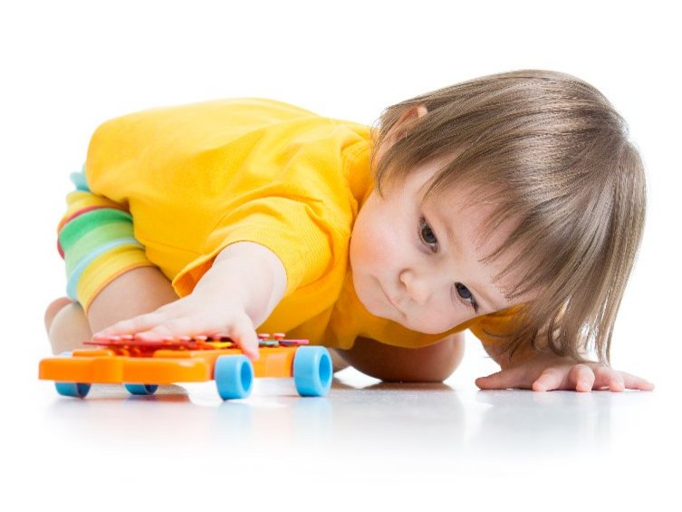 Een peuter met autisme kijkt gefascineerd aar de wielen van zijn speelgoed auto