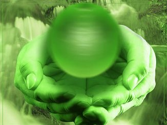 Twee handen van een paranormaal therapeut, waar een groene bal genezende energie boven zweeft