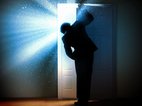 Een man gluurt achter een toilet deur, er komt stralend licht uit het toilet