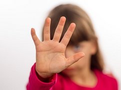 Jong meisje maakt stop-gebaar met haar hand, om het pesten te stoppen.
