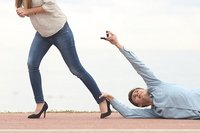 Een stel met relatieproblemen. De vrouw loopt weg maar de man sleept over de vloer, hangend aan haar enkel, terwijl hij een trouwring aan haar aanbiedt.