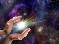 De geboorte van het licht: twee handen bevrijden een stralend lichtje, tegen een donkere sterrenhemel.