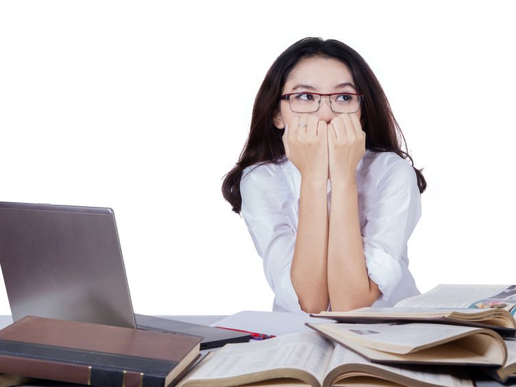 Een angstige hooggevoelige vrouw zit achter de laptop een sollicitatiebrief te schrijven
