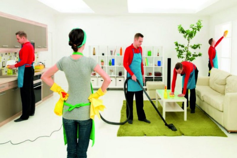 Een man maakt het huis schoon terwijl de vrouw ernaar staat te kijken