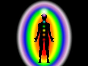 Een silhouet van een man met felle kringen in de kleuren van de regenboog om zijn lichaam.