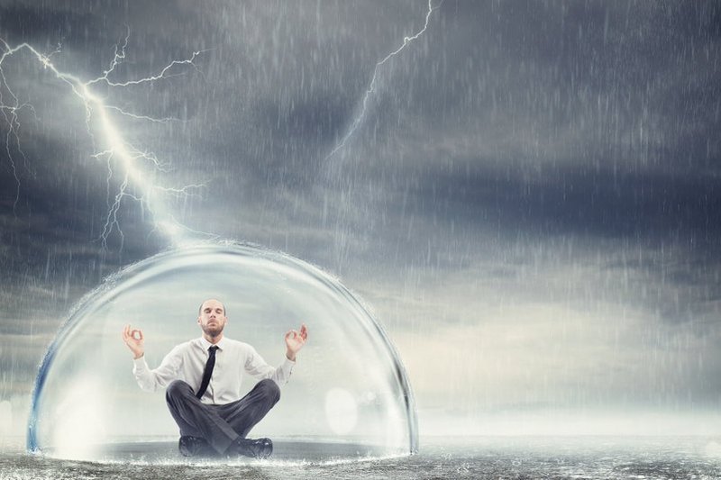 Een man zit veilig en rustig, beschermd tegen onweer en overprikkling, onder een glazen stolp