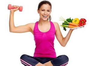 Een vrouw in sportkleding zit in kleermakerszit. In de ene hand een gewicht, in de andere een bord gezonde voeding.