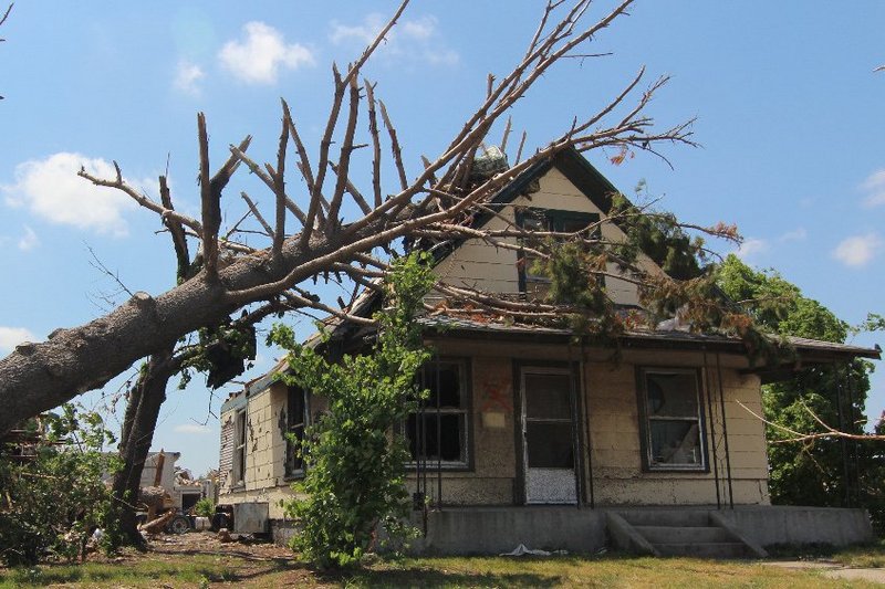 Een huis met eenn trauma, er is een boom op het dak gevallen. De kern van dit trauma: Je kunt het dak pas repareren als die boom er af is.