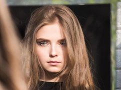 Een hooggevoelige vrouw kijkt onzeker in de spiegel