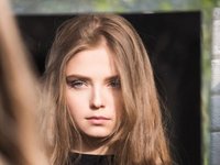 Een hooggevoelige vrouw kijkt onzeker in de spiegel